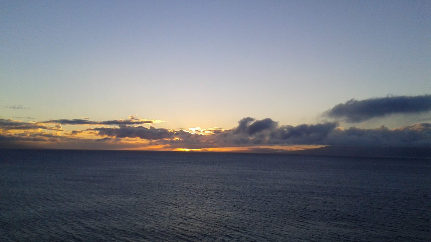 Wide ocean horizon at dusk with soft clouds